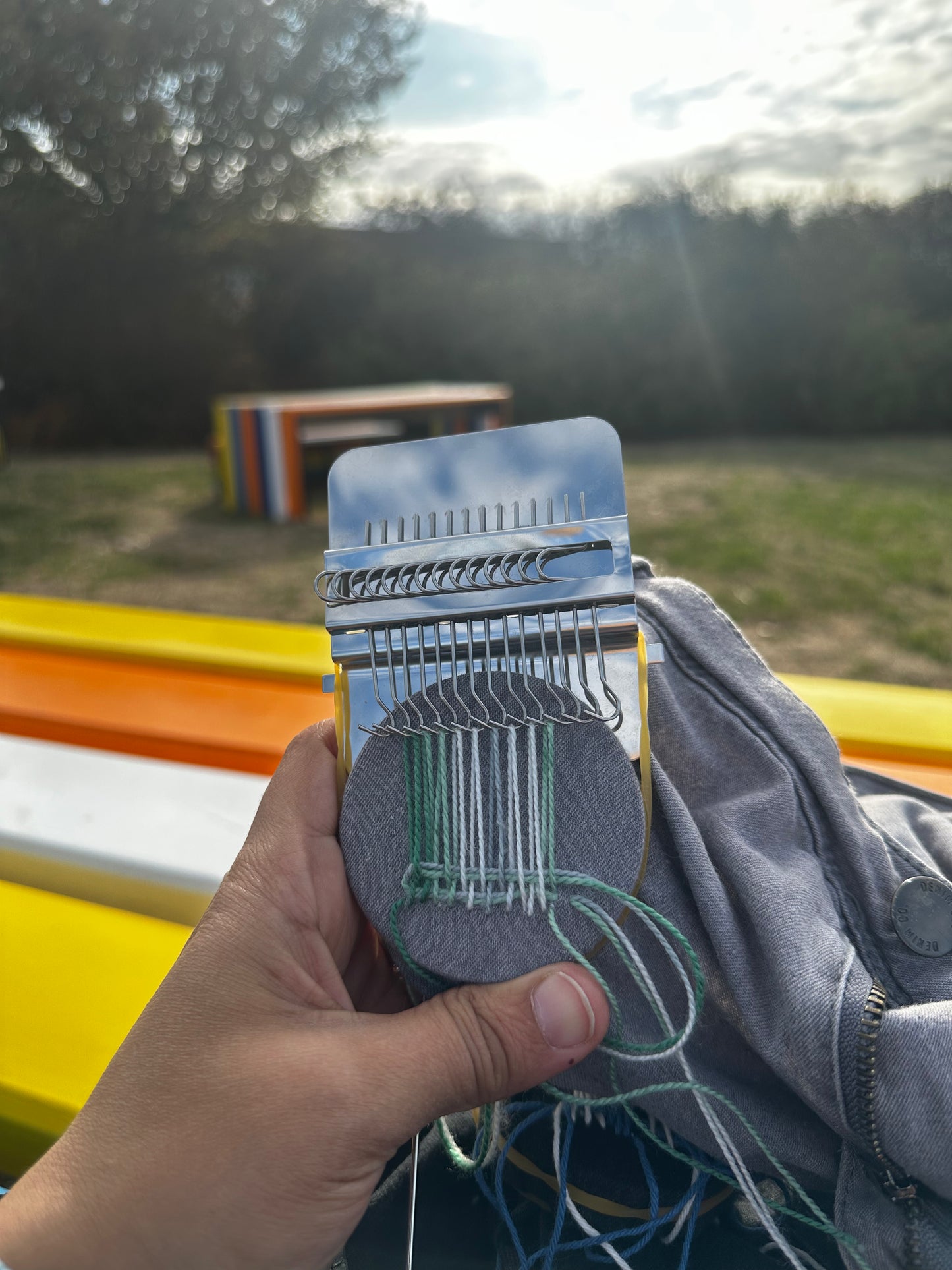 Kit Mayha Créa en utilisation dans un parc — réparation jean gris avec fils verts

